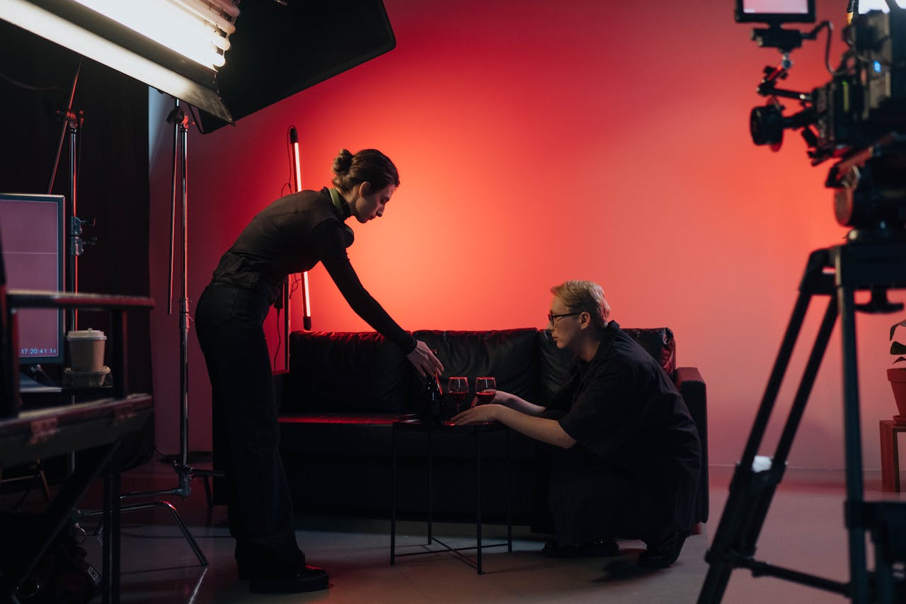 Behind-the-scenes view of a film crew in action, setting up a studio scene with lighting and equipment.